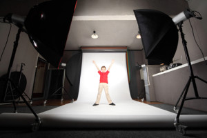 interior of professional photo studio boy in red shirt standing